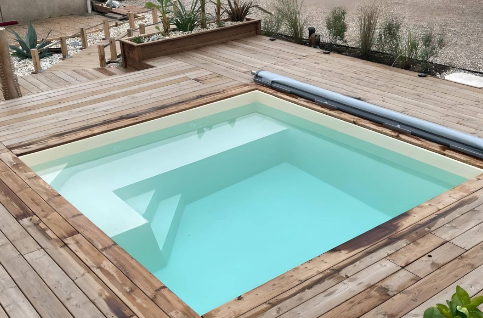CARNAU : piscine coque polyester carrée avec volet immergé, pensée pour les espaces contemporains.