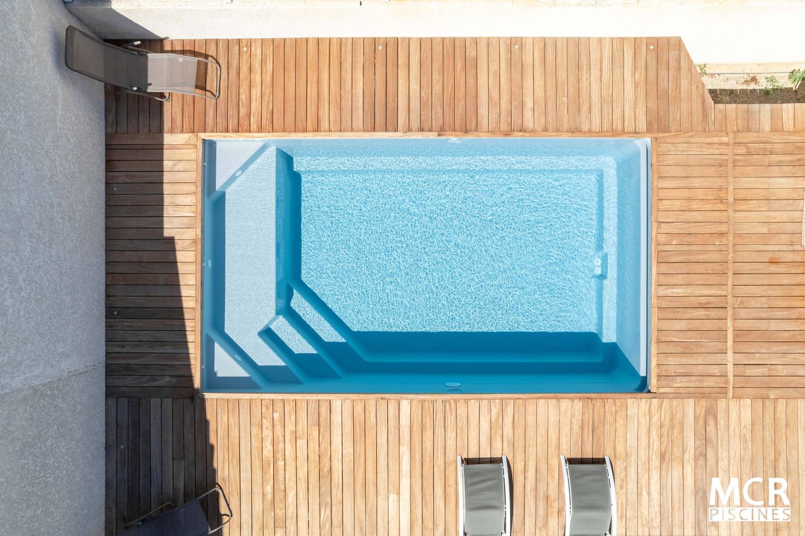 Piscine coque polyester Moana avec escalier d'angle, plage et volet immergé pour un extérieur raffiné - Mcr Piscines et Spas, Caissargues