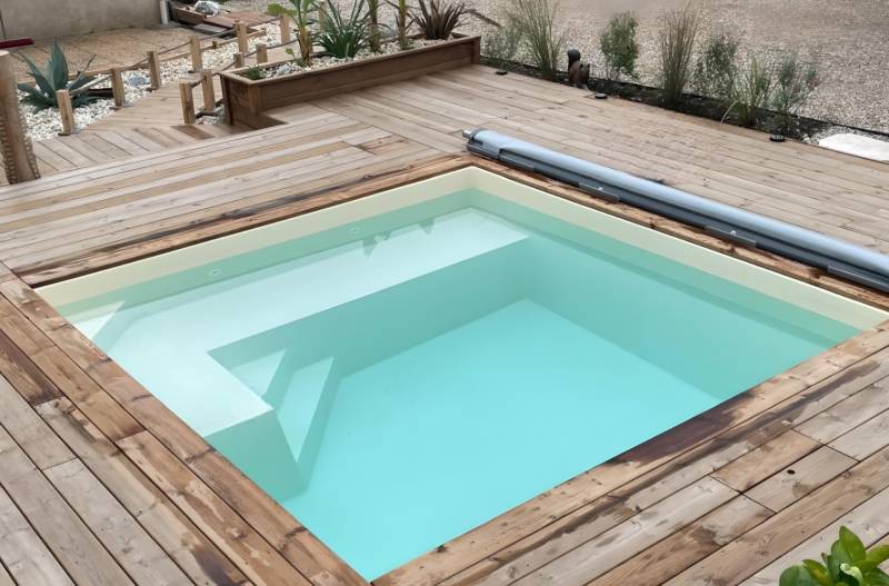 CARNAU : piscine coque polyester carrée avec volet immergé, pensée pour les espaces contemporains.