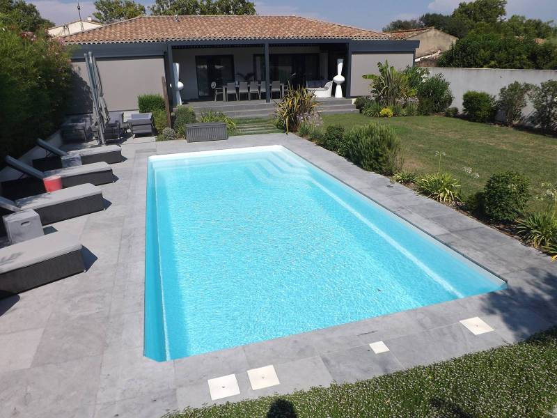 BALI : Piscine coque polyester de forme rectangulaire avec escalier d'angle et une banquette