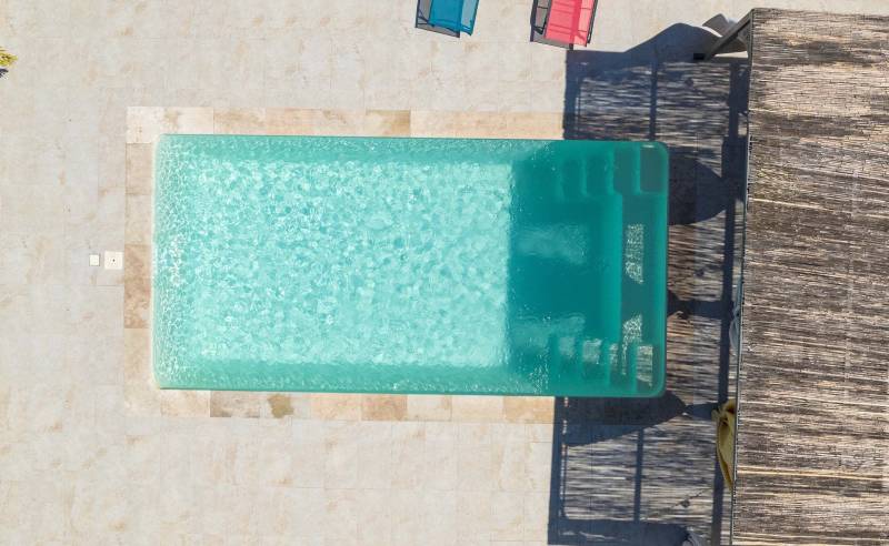 Piscine coque polyester modèle Jersey à Nîmes – Fonctionnalité et confort avec banquette centrale et escaliers latéraux