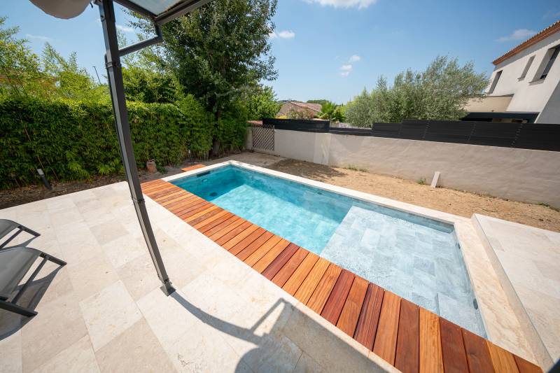 Piscine traditionnelle en PVC armé imitation pierre de Bali avec grande plage : luxe et confort - Mcr Piscines et Spas, Caissargues