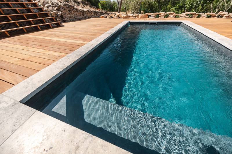 Piscine traditionnelle en panneaux Cofreco et margelles travertin gris 5 cm bord droit : design et robustesse - Mcr Piscines et Spas, Caissargues