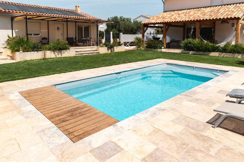 Piscine coque polyester Motu avec plage, volet immergé et escalier d'angle pour un extérieur chic - Mcr Piscines et Spas, Vergèze