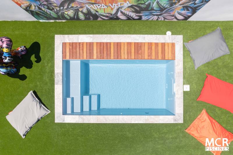 Piscine coque polyester Maéa avec escalier d'angle, grande banquette et couverture automatique intégrée - Mcr Piscines et Spas, Caissargues