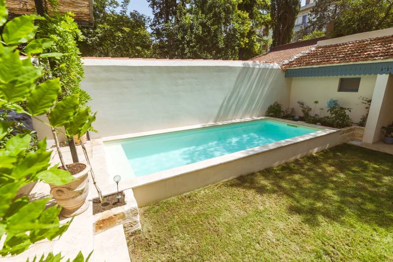 Piscine traditionnelle avec finition en membrane armée sable et margelles en travertin beige : design et durabilité - Mcr Piscines et Spas, Nîmes