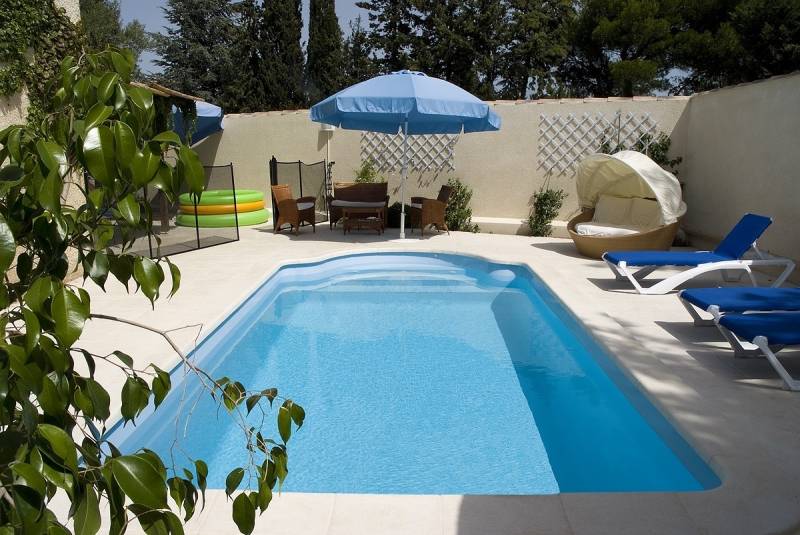 Piscine coque polyester modèle Sicile à Nîmes – Élégance et confort avec plage centrale et escaliers sur les côtés
