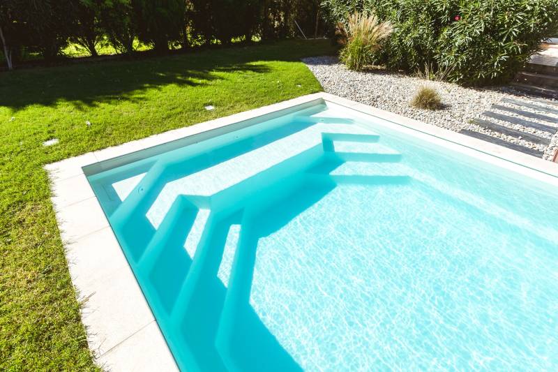 Piscine coque polyester modèle Maatea à Vestric et Candiac – Confort et praticité avec banquette et escaliers intégrés
