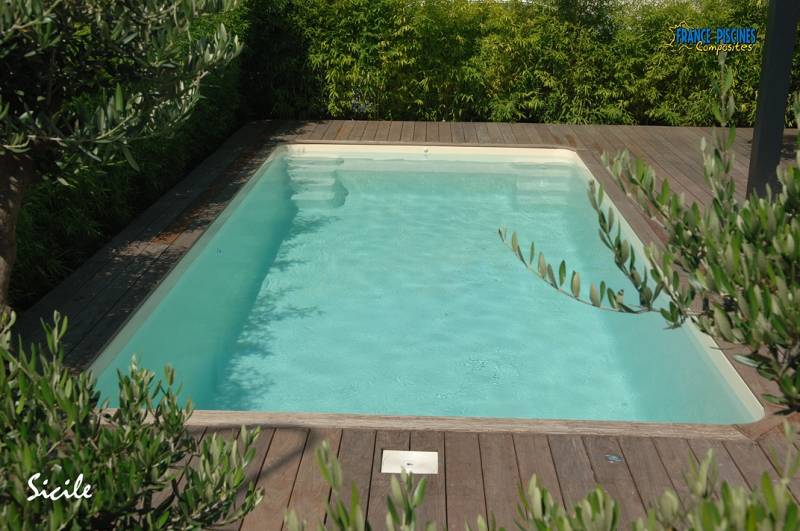 Piscine coque polyester modèle Sicile à Nîmes – Élégance et confort avec plage centrale et escaliers sur les côtés